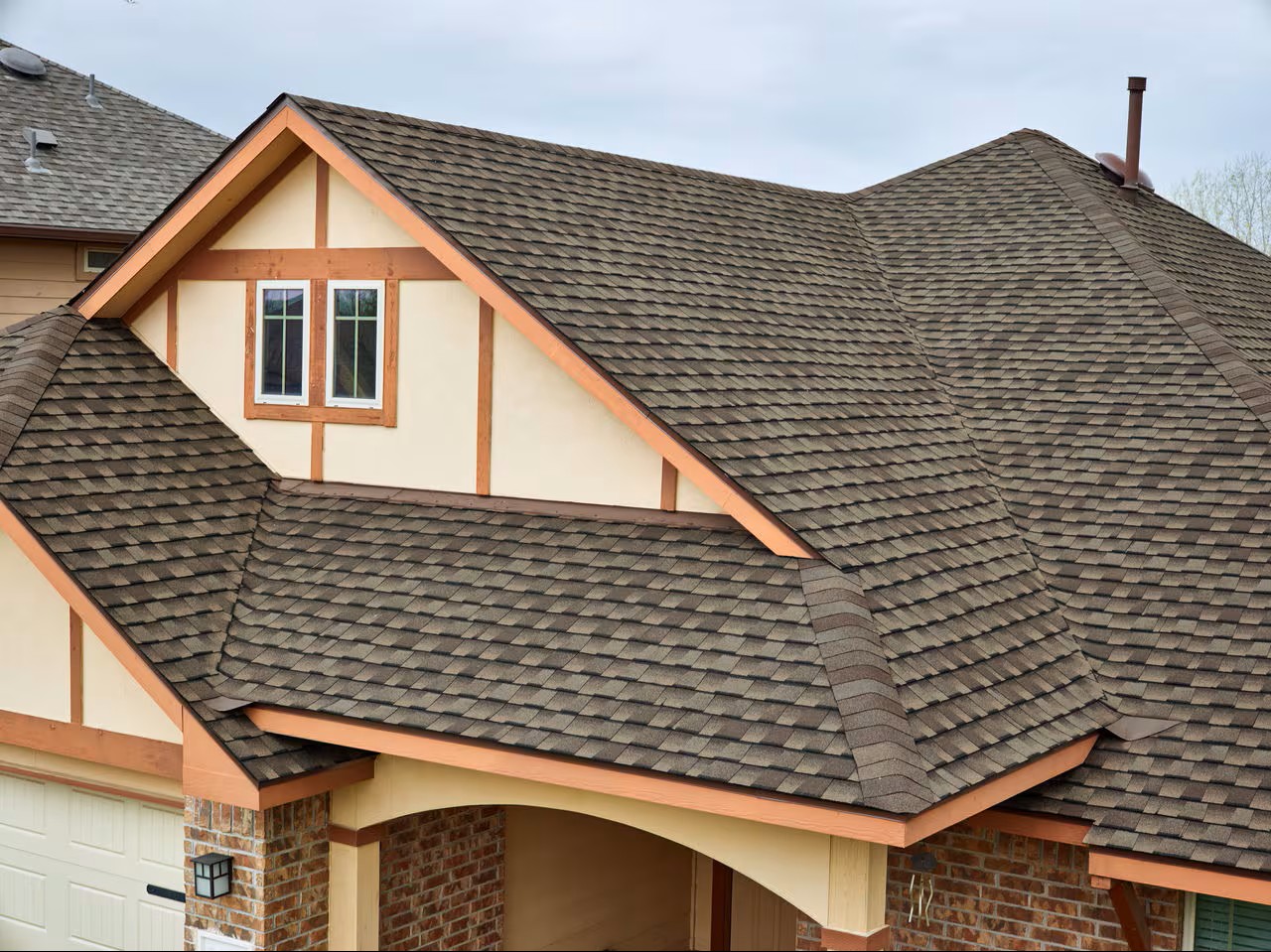 Finished GAF Timberline shingle roof on a Tudor-style home with copper accents